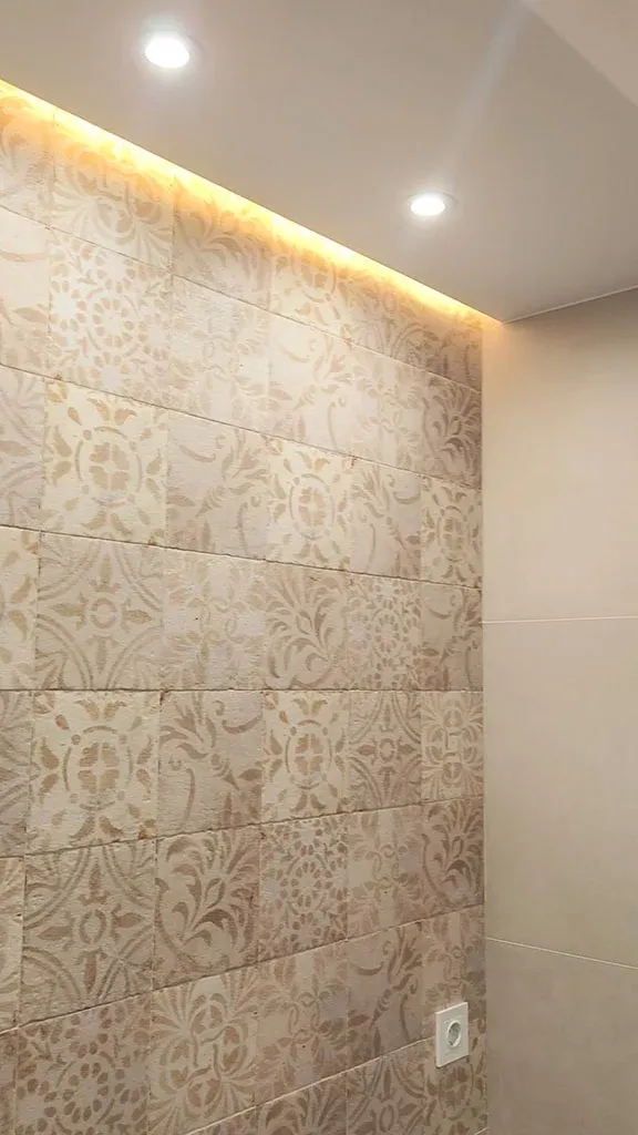 Pared con baldosa hidráulica iluminada por una tira de luz indirecta