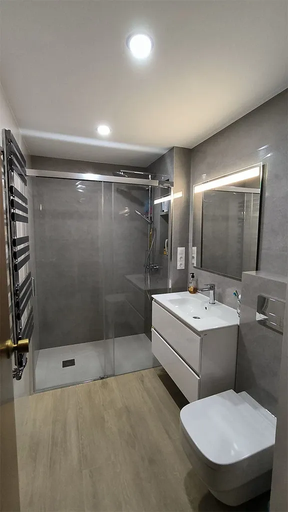 Baño principal reformado con ducha a ras de suelo y mueble suspendido